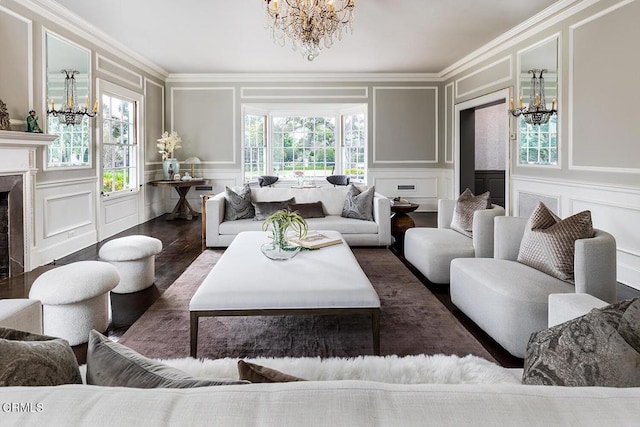 living area featuring a healthy amount of sunlight, a premium fireplace, a decorative wall, and a notable chandelier