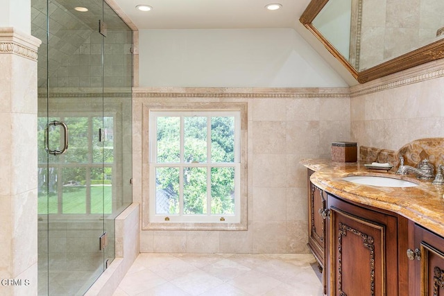 full bathroom with a stall shower, recessed lighting, vanity, and tile walls