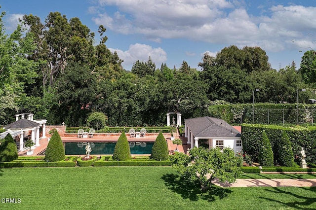 view of property's community featuring a yard, fence, and a pool