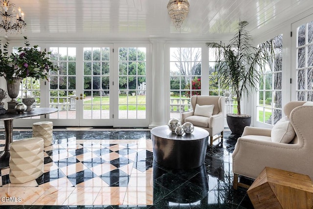 sunroom / solarium with plenty of natural light and a chandelier