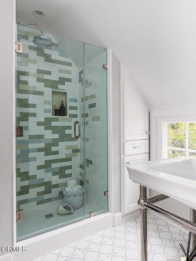 bathroom featuring a stall shower and vaulted ceiling