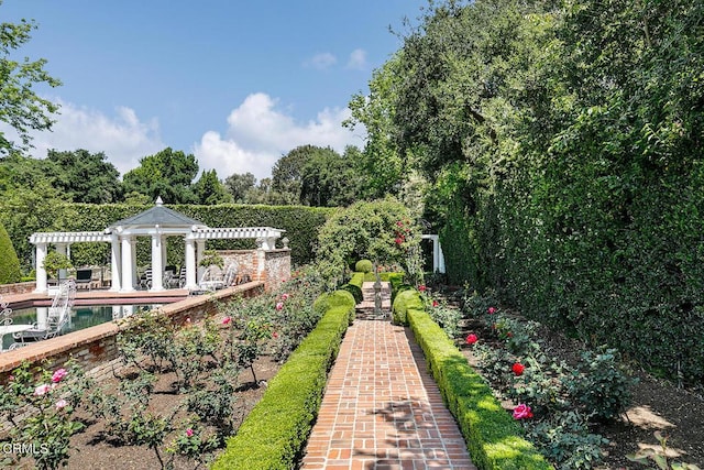 view of yard with an outdoor pool and a pergola