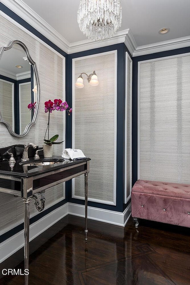 interior space with ornamental molding, a chandelier, a sink, and baseboards