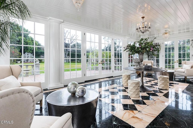 sunroom / solarium with wood ceiling, french doors, a notable chandelier, and ornate columns