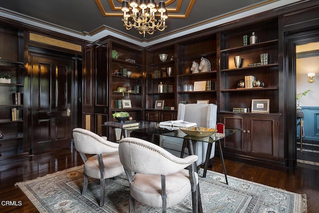 sitting room with dark wood-style floors, a chandelier, built in features, and ornamental molding