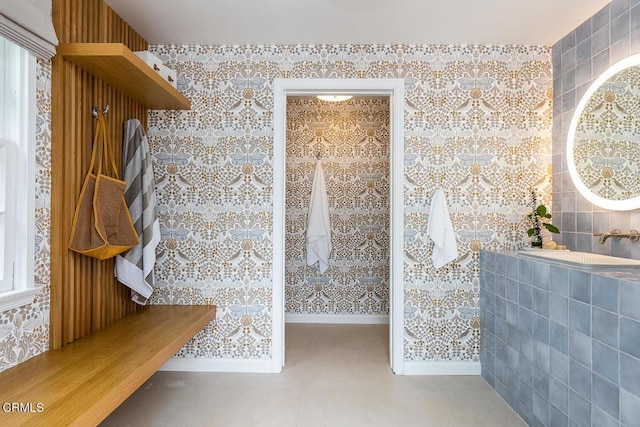 bathroom with wallpapered walls, baseboards, and tile patterned floors