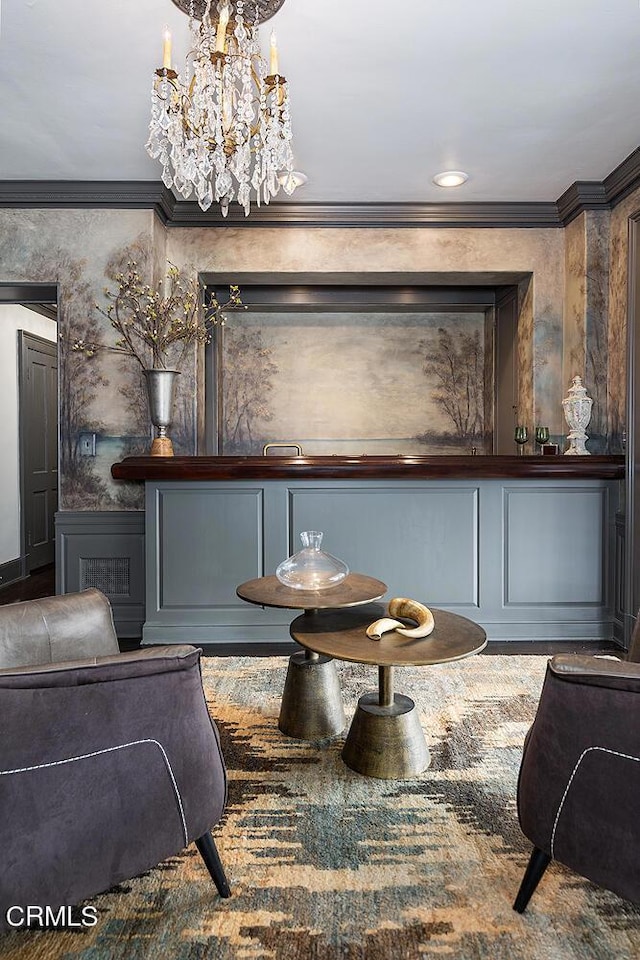 interior space with ornamental molding, wainscoting, a notable chandelier, and a decorative wall