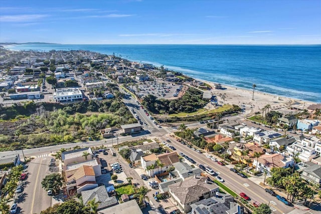 drone / aerial view featuring a water view, a residential view, and a beach view