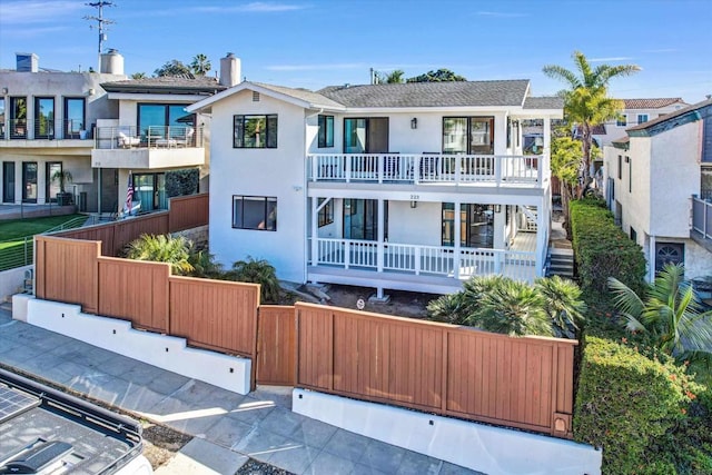 view of front of house featuring a fenced front yard, a balcony, and stucco siding