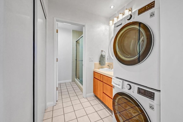 washroom with laundry area, stacked washing maching and dryer, light tile patterned flooring, and baseboards