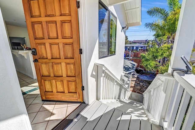 view of exterior entry featuring a balcony and stucco siding