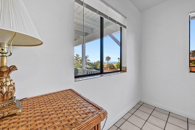 empty room featuring baseboards and light tile patterned flooring