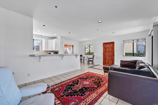 living area featuring light tile patterned floors, baseboards, and recessed lighting