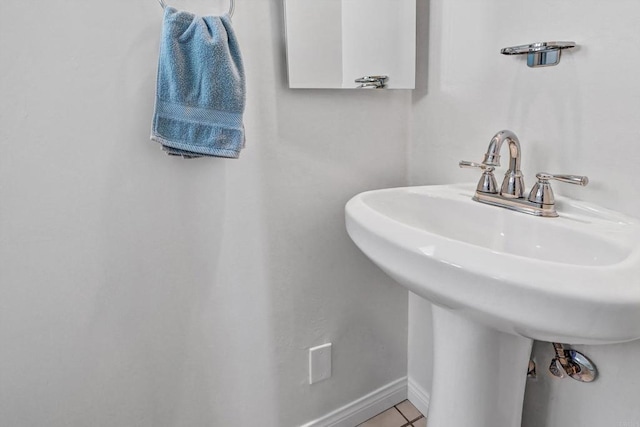 bathroom featuring tile patterned flooring, a sink, and baseboards