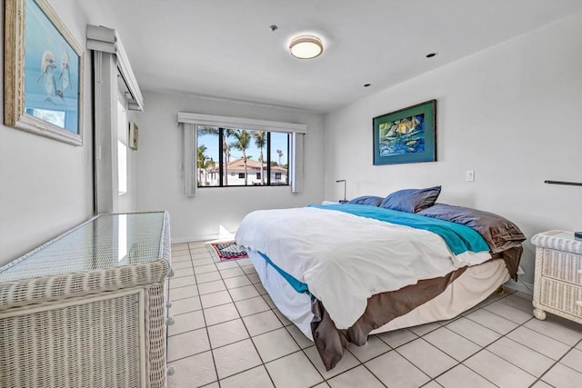 bedroom with light tile patterned floors and baseboards