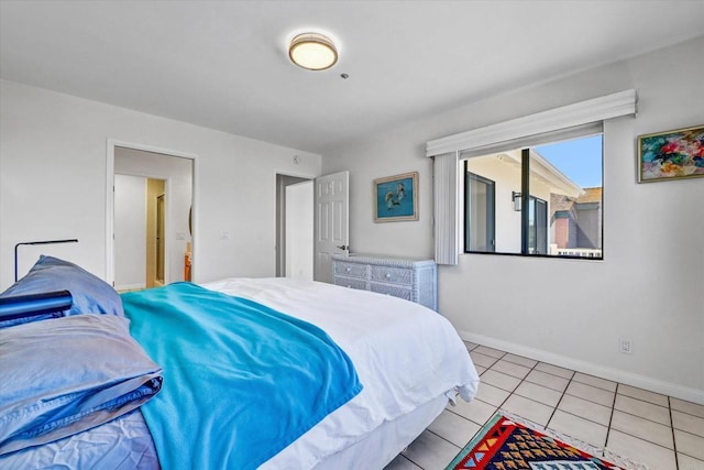 bedroom featuring light tile patterned flooring and baseboards