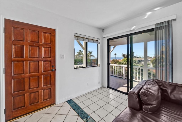 entryway with baseboards and light tile patterned floors