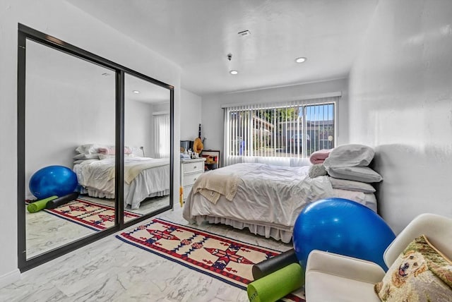 bedroom featuring marble finish floor, a closet, and recessed lighting