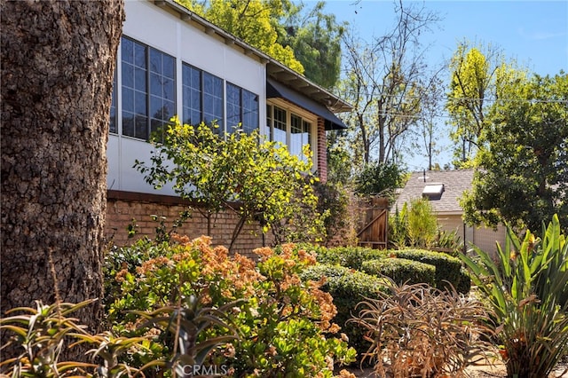 view of side of home with a shingled roof