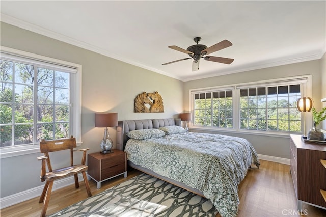 bedroom with light wood-style floors, baseboards, a ceiling fan, and ornamental molding