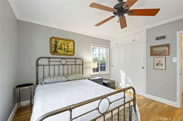 bedroom featuring light wood-style floors, visible vents, and ornamental molding