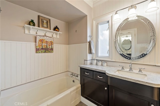 full bathroom with a wainscoted wall, a garden tub, and vanity