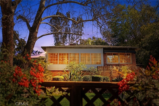 view of side of property featuring a sunroom and brick siding