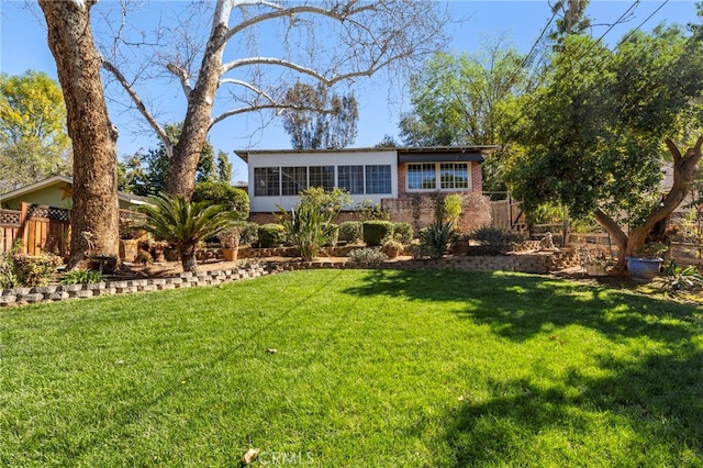 view of front of property with brick siding, fence, and a front yard