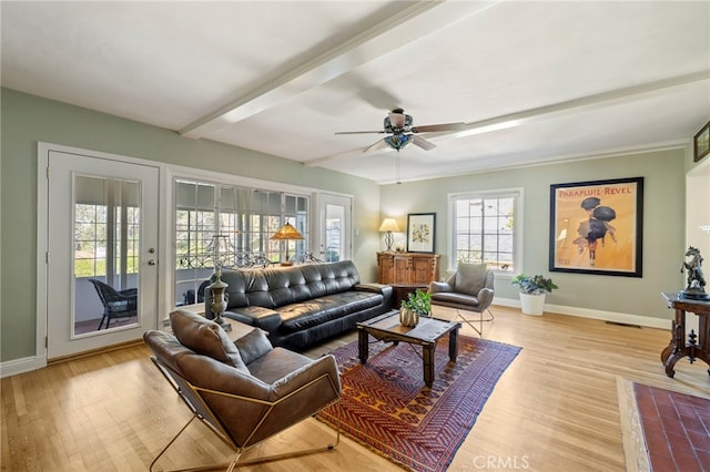 living room featuring light wood-style flooring, baseboards, ceiling fan, and beam ceiling