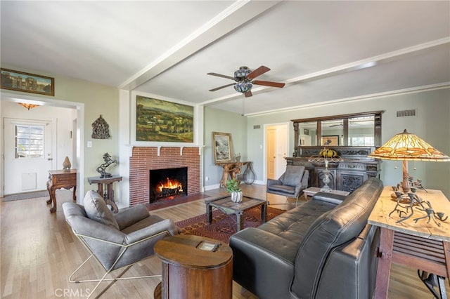 living area with a wealth of natural light, light wood-type flooring, visible vents, and a fireplace