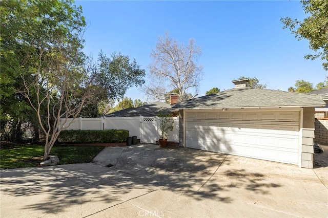 view of side of property featuring a garage and fence