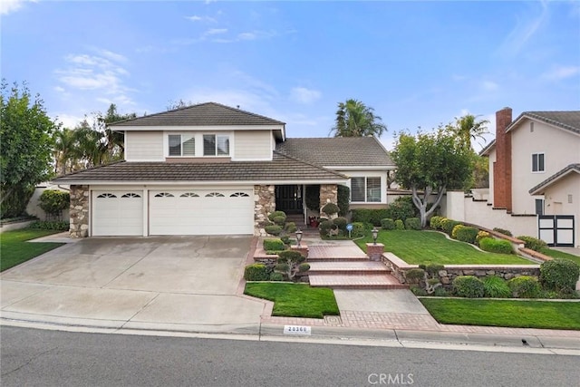 traditional-style house featuring a garage, a tile roof, stone siding, concrete driveway, and a front yard