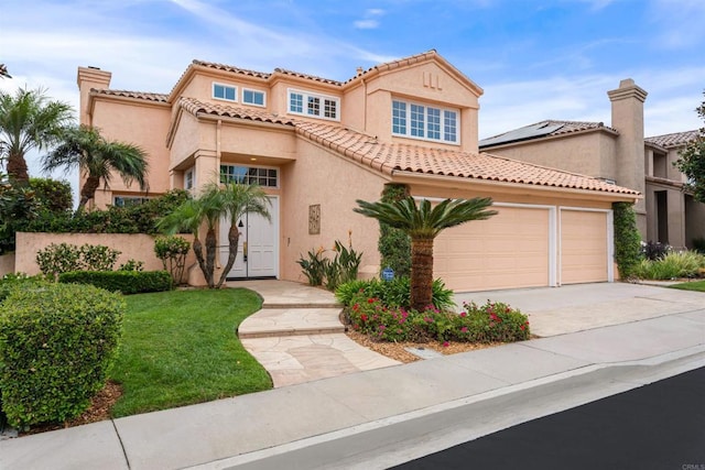 mediterranean / spanish home featuring a garage, driveway, a tiled roof, stucco siding, and a front lawn