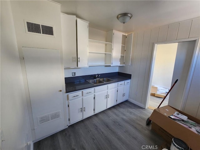 kitchen with dark countertops, visible vents, white cabinetry, and open shelves