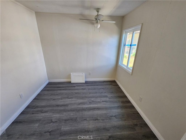 spare room with dark wood-style floors, ceiling fan, and baseboards