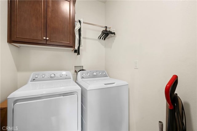 laundry area with independent washer and dryer and cabinet space