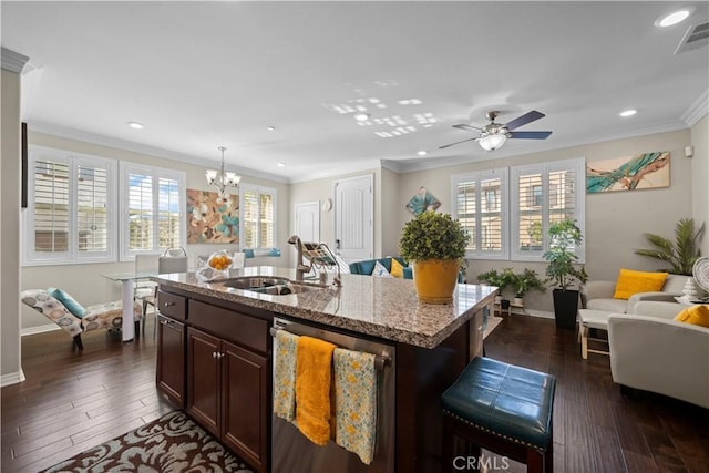 kitchen featuring a center island with sink, ornamental molding, light stone countertops, stainless steel dishwasher, and a sink