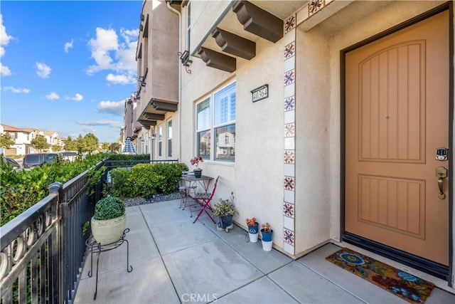 doorway to property with a balcony and stucco siding