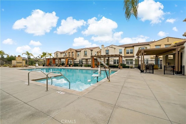 community pool featuring a patio area, a residential view, fence, and a pergola