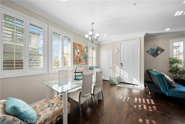 dining room featuring ornamental molding, dark wood-type flooring, baseboards, and an inviting chandelier