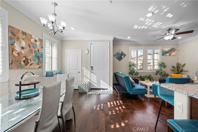 dining room with dark wood-type flooring, crown molding, and ceiling fan with notable chandelier