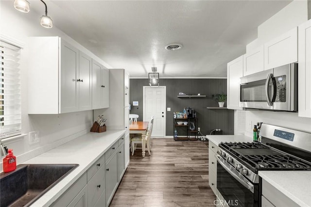 kitchen featuring stainless steel appliances, white cabinets, light countertops, and visible vents