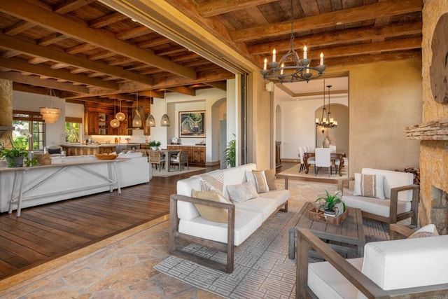 5423 Calzada Del Bosque, Rancho Santa Fe, CA 92067 - living room with a chandelier, arched walkways, a wooden ceiling with exposed beams, and stone finish floors