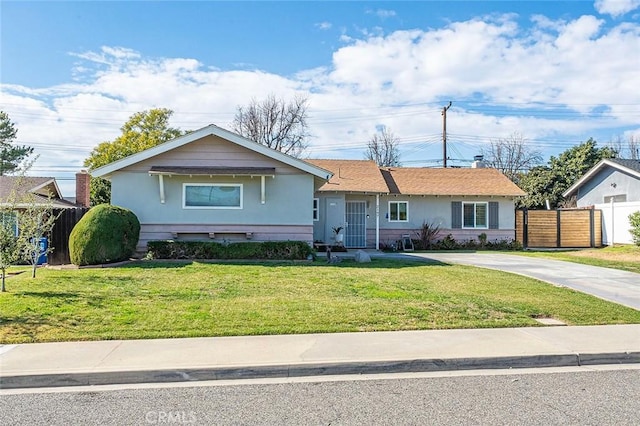 single story home featuring concrete driveway, a front yard, fence, and stucco siding