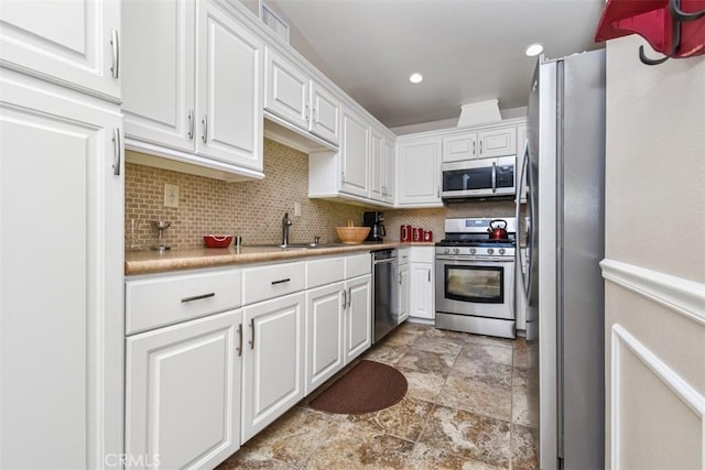 kitchen featuring white cabinetry, stainless steel appliances, and light countertops