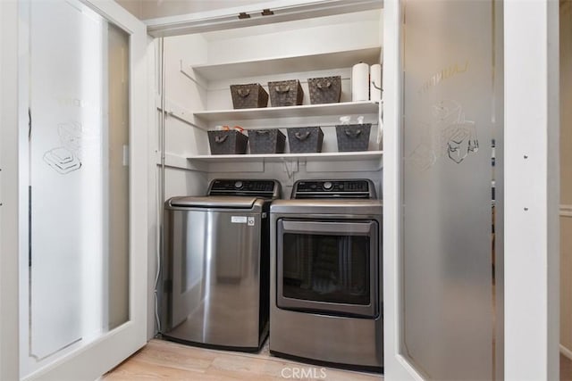 laundry area featuring laundry area, light wood-style flooring, and washing machine and clothes dryer