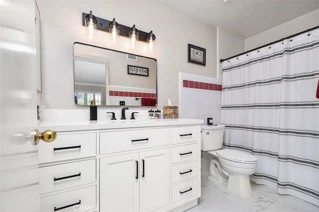 bathroom with toilet, marble finish floor, curtained shower, and vanity