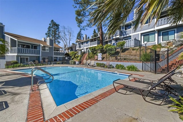 pool featuring a residential view, fence, and a patio