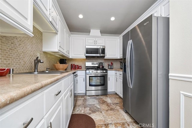 kitchen featuring stainless steel appliances, white cabinets, light countertops, and a sink