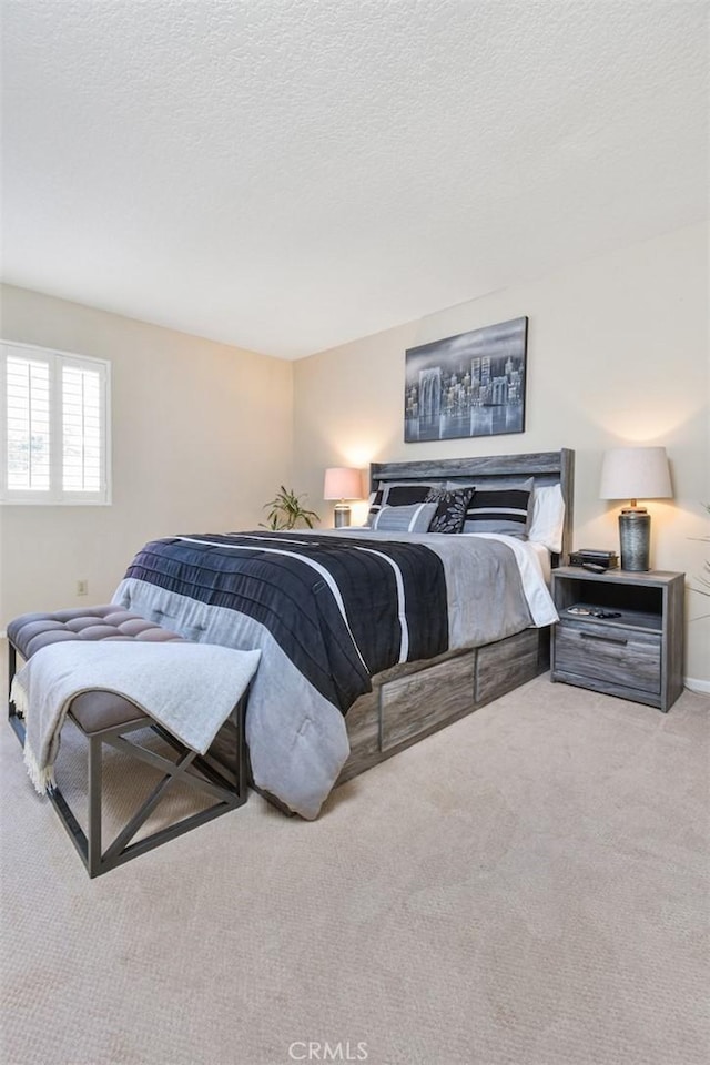 bedroom with light carpet and a textured ceiling